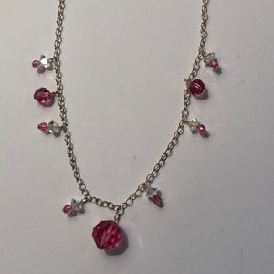 Silver necklace with pink crystals.